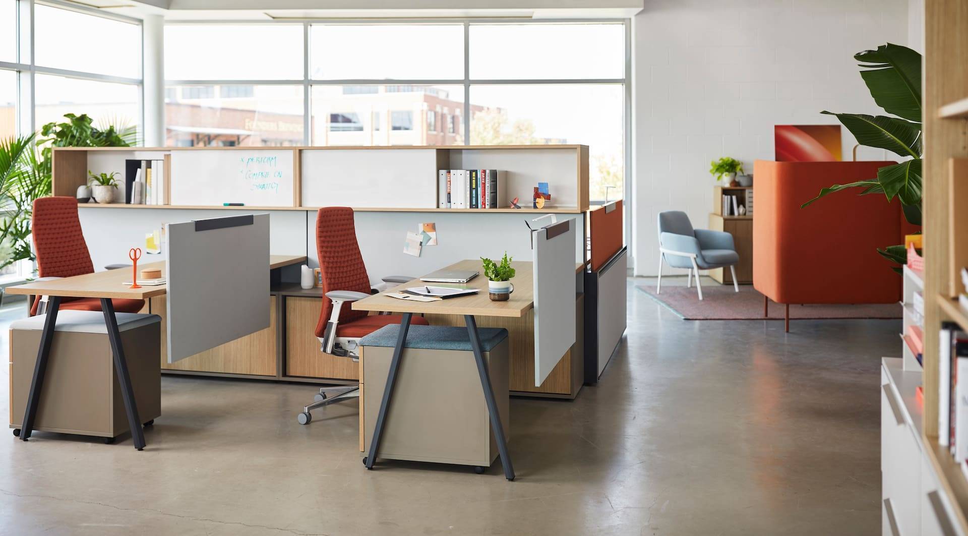 A modern workplace with desks and plants.